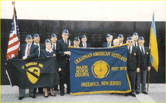 Ukrainian American Veterans (UAV) Post 30 members holding post flag at tribute to their patron, Major Myron Diduryk, at the inscription of his name on the New Jersey Vietnam Veterans Memorial in Holmdel, NJ